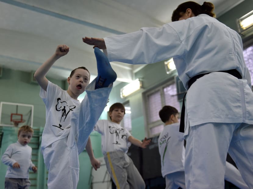 A photo taken on February 26, 2016 in Kiev shows nine-year-old Artyom , affected by a Down syndrome, taking part in a karate training session with karate coach Nataliya Milko. In 2013 Nataliya Milko, founded the first group for children with Down syndrome as an experiment. Photo: AFP