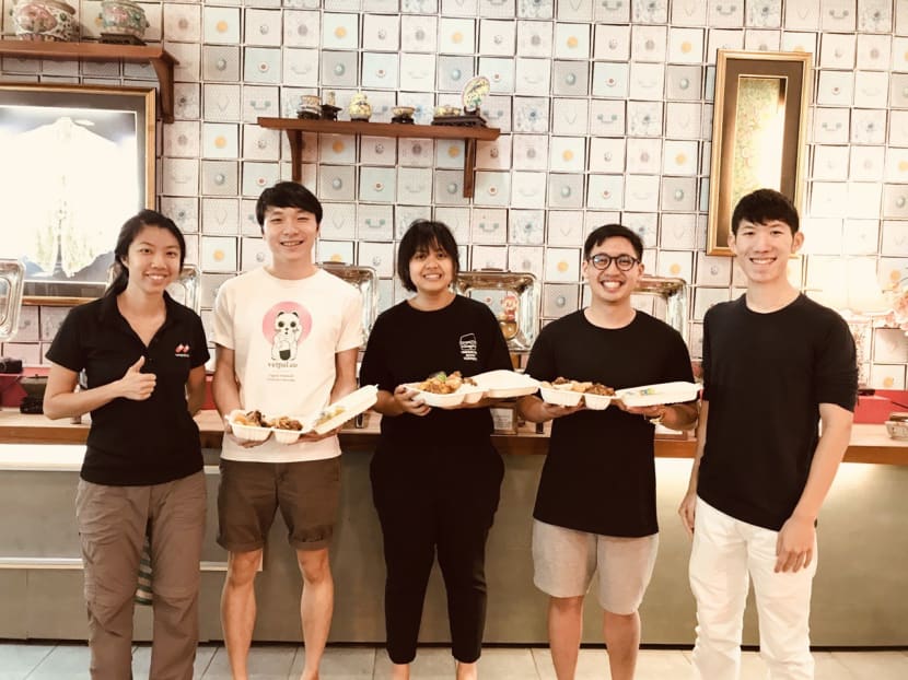 Mr Preston Wong (extreme right), co-founder of treatsure, with some of the mobile app’s users at Chilli Padi Nonya Café at the National University of Singapore. This Chinese New Year, treatsure has teamed up with several hotels to let users of its app pack excess buffet food from S$10 onwards.