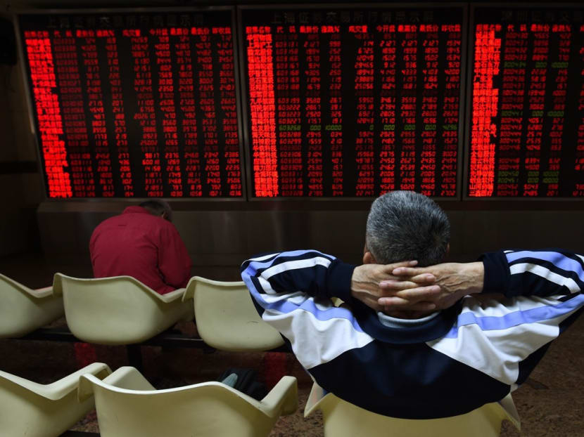 An investor watches stock price movements at a securities company in Beijing. Photo: AFP