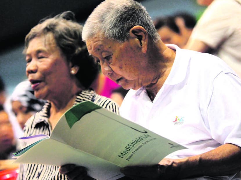 An elderly gentleman present at a health dialogue at Hong Kah Community Club browsing through a MediShield Life folder. TODAY file photo