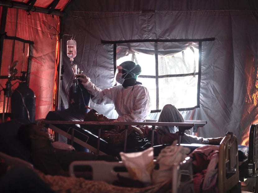Medical personnel tend to Covid-19 patients in a tent set up outside a hospital in Bogor on June 29, 2021, as infections soar in Indonesia. Medical personnel tend to Covid-19 patients in a tent set up outside a hospital in Bogor on June 29, 2021, as infections soar in Indonesia.