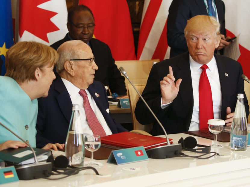 From left: Mrs Merkel talking to Tunisia president Beji Caid Essebsi and Mr Trump at the G7 Summit on Saturday. Analysts say Mrs Merkel’s comments are an acknowledgement of the new reality that the US is heading in a direction on key issues that seems diametrically opposite to where Europe is going. Photo: Reuters