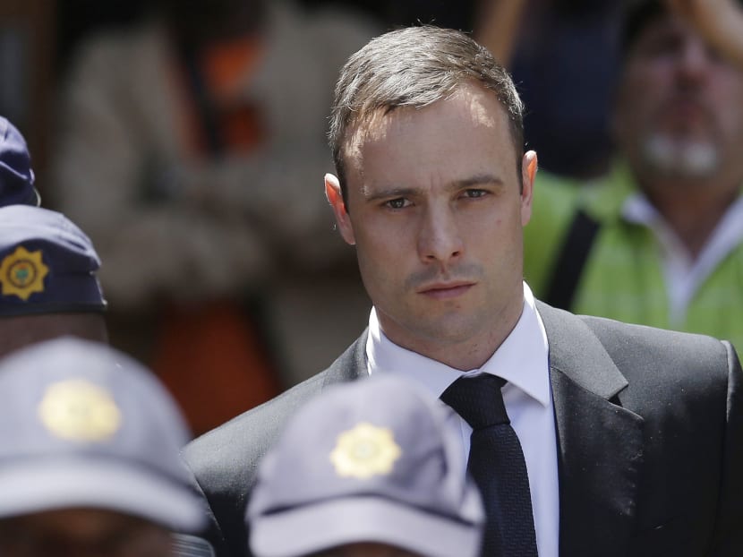 In this Friday, Oct. 17, 2014 file photo, Oscar Pistorius is escorted by police officers as he leaves the high court in Pretoria, South Africa. Photo: AP