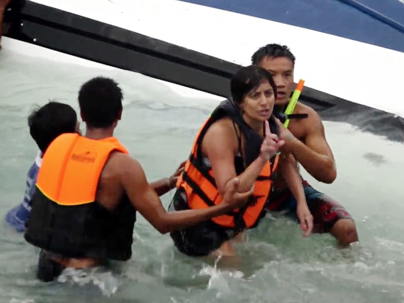 A woman gestures after she was rescued from a capsized boat on Koh Samui, Thailand. Photo: AP