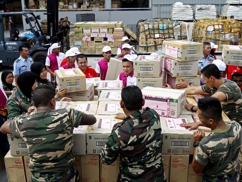 Volunteers and air force personnel preparing relief supplies to be sent to Malaysia’s flood-hit east coast states yesterday. Photo: AP