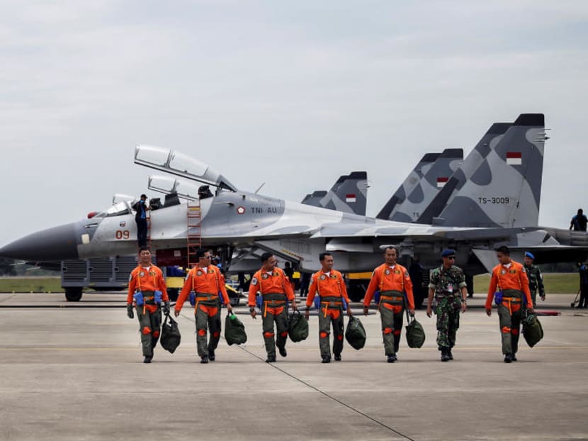 In this 2016 file photo, Indonesian Air Force Sukhoi fighter pilots and crew walk across the tarmac after training for an upcoming military exercise at Hang Nadim Airport, Batam, Riau Islands, Indonesia.