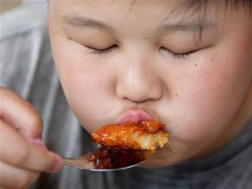 An overweight Chinese boy eats his lunch after a weight reduction class in Beijing. Photo: Reuters