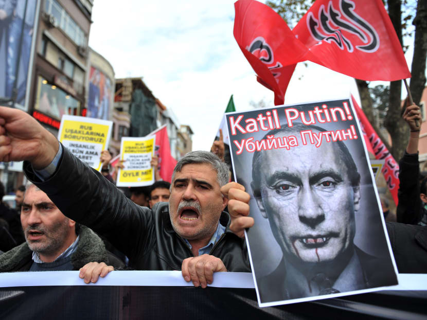 Turkish protesters shout anti-Russia slogans as they hold a poster of Russian President Vladimir Putin. Photo: AP/Omer Kuscu