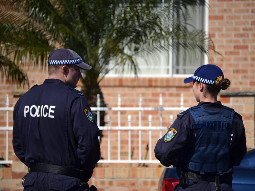 Police officers stand guard outside a house during a raid in the Guildford area of Sydney on Sept 18, 2014.  Photo: AFP
