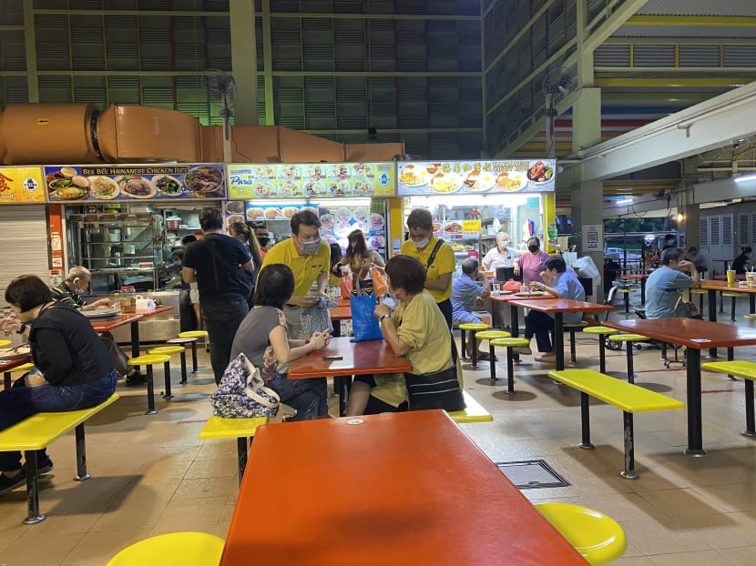 Reform Party's chairman Andy Zhu (left in yellow) speaking to residents at the West Coast Market Square during the party's walkabout on June 19.