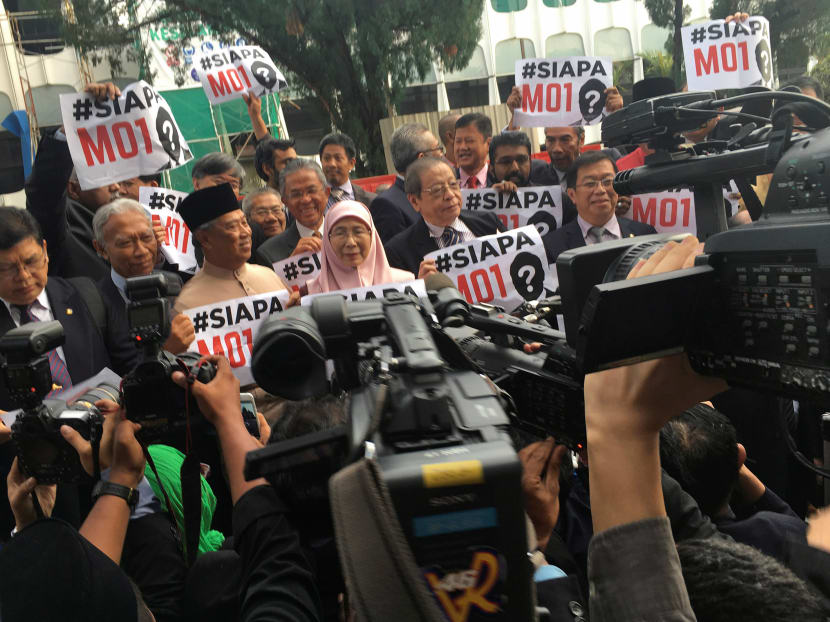 Malaysian Opposition MPs hold up handwritten placards asking "Who is MO1?" after staging a walkout in protest in parliament while Prime Minister Najib Razak was tabling the country's 2017 budget in Kuala Lumpur, on Oct 21, 2016. Photo: Reuters
