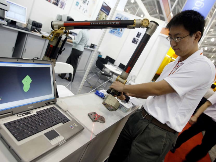 A engineer demontrates a 3D scanning parts used for reverse engineering and inspection of design parts at the Metal Asia 2007 exhibition in Singapore, 28 March 2007. AFP file photo