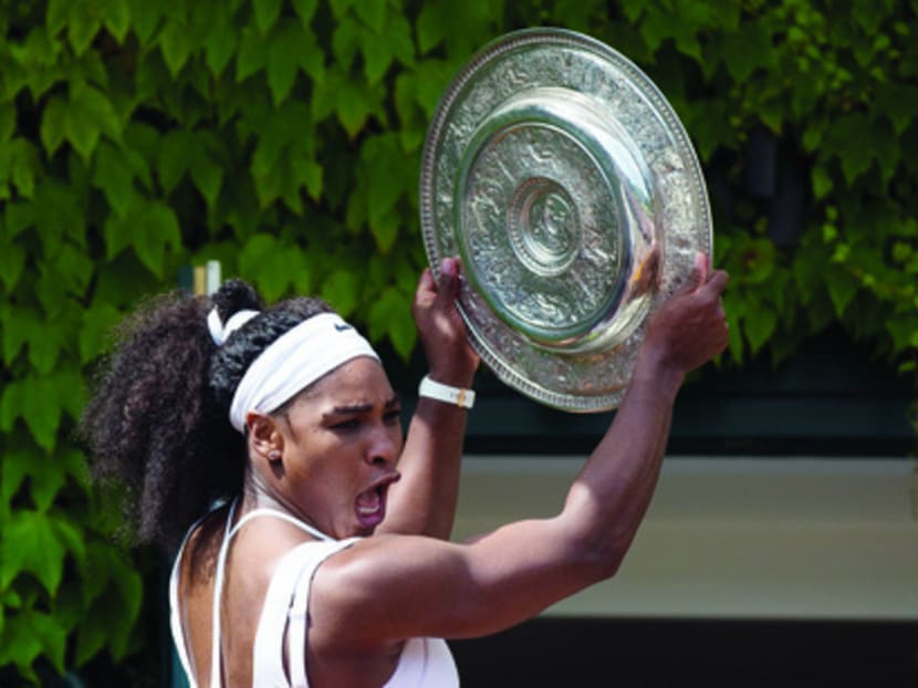 Serena Williams celebrates with her winner’s trophy after beating Garbine Muguruza at Wimbledon on Saturday in London. Photo: Getty Images