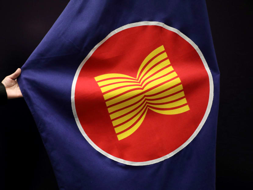 A worker adjusts an Asean flag at a meeting hall in Kuala Lumpur, Malaysia, on Oct 28, 2021.