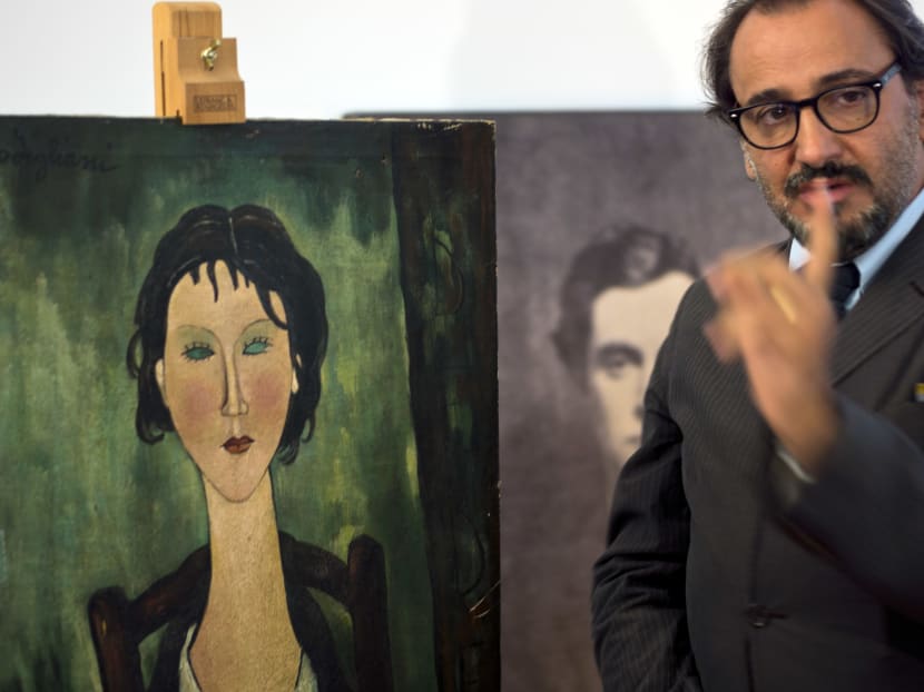 Art historian Alberto D'Atanasio speaking during an interview with the Associated Press in Rome about an unidentified painting, at left, which is under investigation to determine whether it is an authentic work by Italian 20th century master Amedeo Modigliani, portrayed in a photograph at center partially covered. D'Atanasio said: "Nothing makes me think this is a fake." Photo: AP