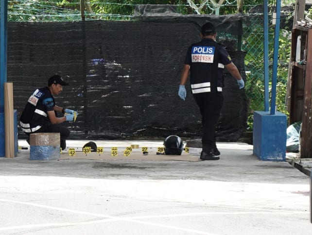 Forensic police officers inspect the scene after the attack at the Ulu Tiram police station in Johor on May 17, 2024.