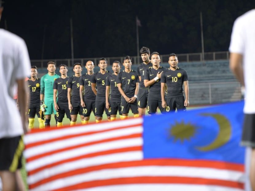 Members of the Malaysian football team standing as their national anthem is played prior to their friendly football match against the Philippines in Manila. Photo: AFP