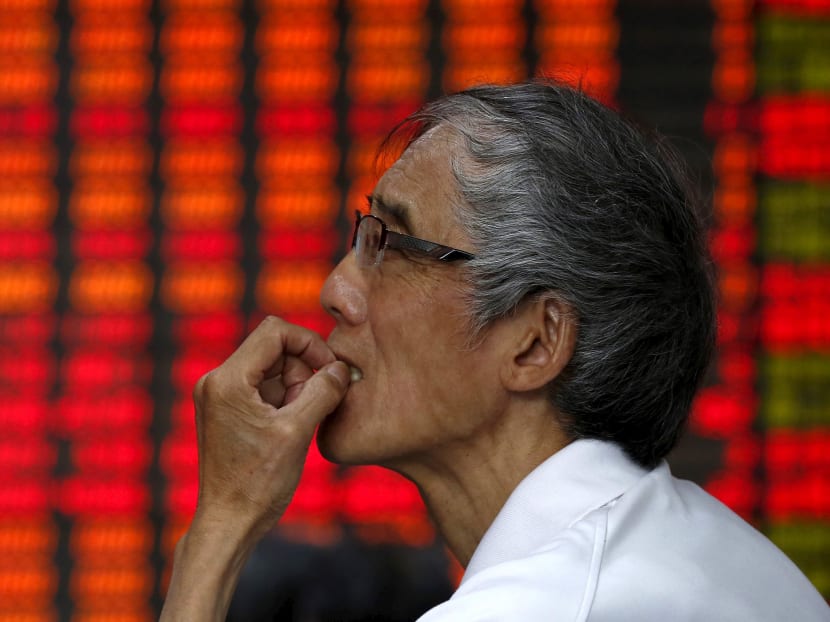 An investor looks at an electronic board showing stock information at a brokerage house in Shanghai, China, July 10, 2015. Photo Reuters