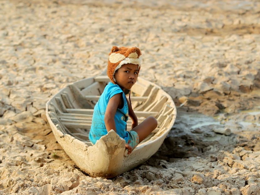 A girl sits on her boat at a Bak Angrout dried up pond at the drought-hit Kandal province in Cambodia, May 13, 2016.