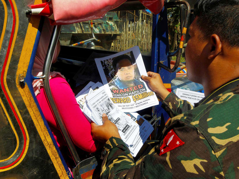 Soldiers distributing pictures of Isnilon Hapilon, the leader of a faction in the extremist Abu Sayyaf Group, in Butig, Lanao del Sur, in the southern Philippines, in February. The United States government is offering a bounty of US$5 million (S$7 million) for his capture. Photo: Reuters