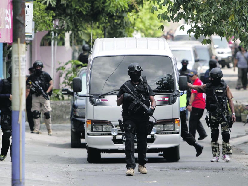 An Indonesian anti-terror squad walks near the house of a suspected militant after a police raid in Solo, Central Java, Indonesia Sunday, Sept 23, 2012. AP file photo