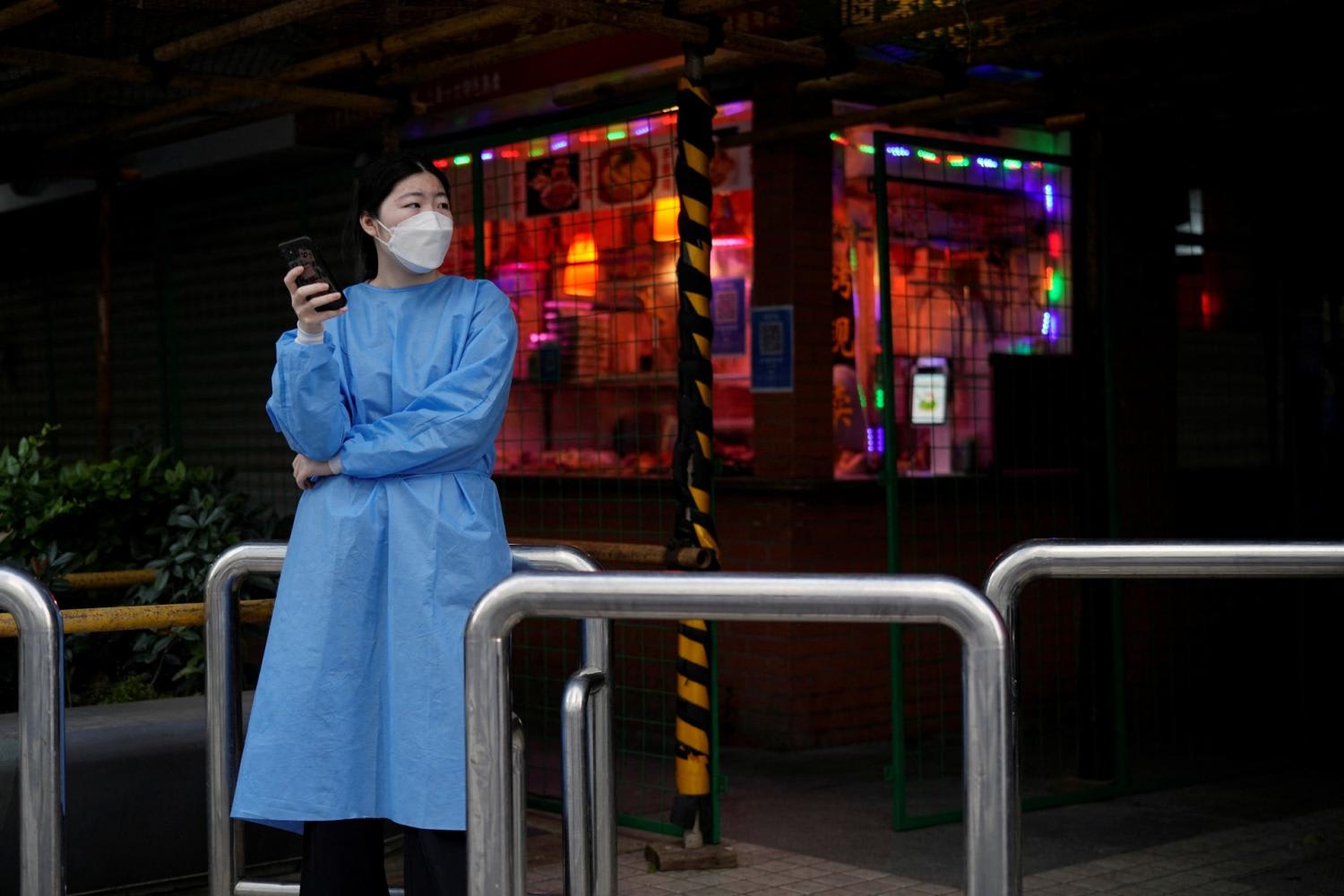 A woman wearing protective gear stands near a food store behind makeshift fences, after the lockdown placed to curb the Covid-19 outbreak was lifted in Shanghai, China on June 2, 2022. A woman wearing protective gear stands near a food store behind makeshift fences, after the lockdown placed to curb the Covid-19 outbreak was lifted in Shanghai, China on June 2, 2022.