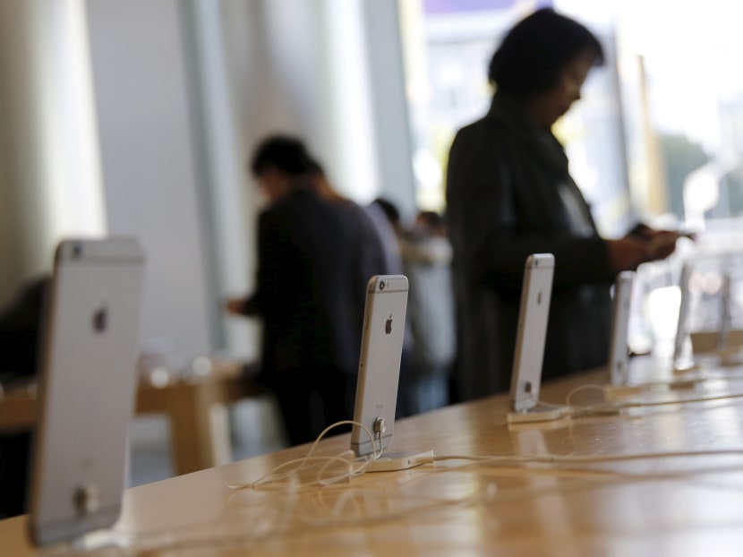 A woman tries apple's iPhone 6 at an Apple store in Beijing, in this Nov 2, 2015 file photo. Photo: Reuters