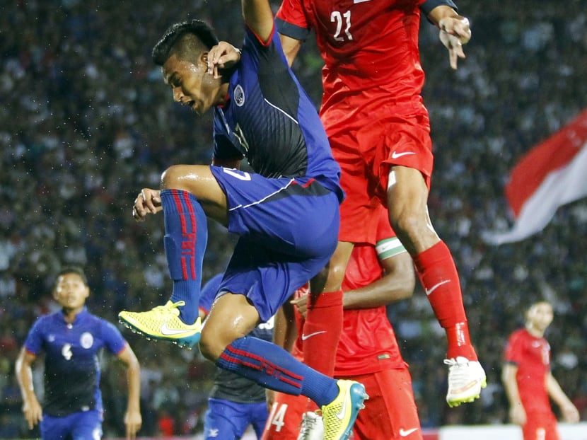 Singapore's Muhammad Safuwan Bin Baharudin (R) jumps for the ball with Cambodia's Soun Veasna during their 2018 World Cup qualifying soccer match at the Olympic Stadium in Phnom Penh June 11, 2015. Photo: Reuters