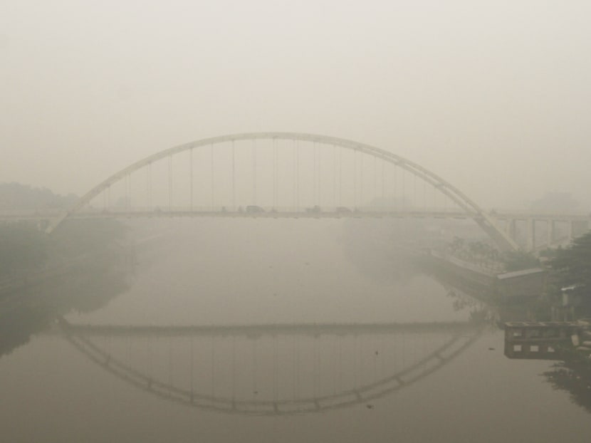 Vehicles drive across a bridge over Siak river in the haze-covered city of Pekanbaru, Riau province, on the island of Sumatra. The smoke has made tens of thousands of people sick. Photo: Reuters Vehicles drive across a bridge over Siak river in the haze-covered city of Pekanbaru, Riau province, on the island of Sumatra. The smoke has made tens of thousands of people sick. Photo: Reuters