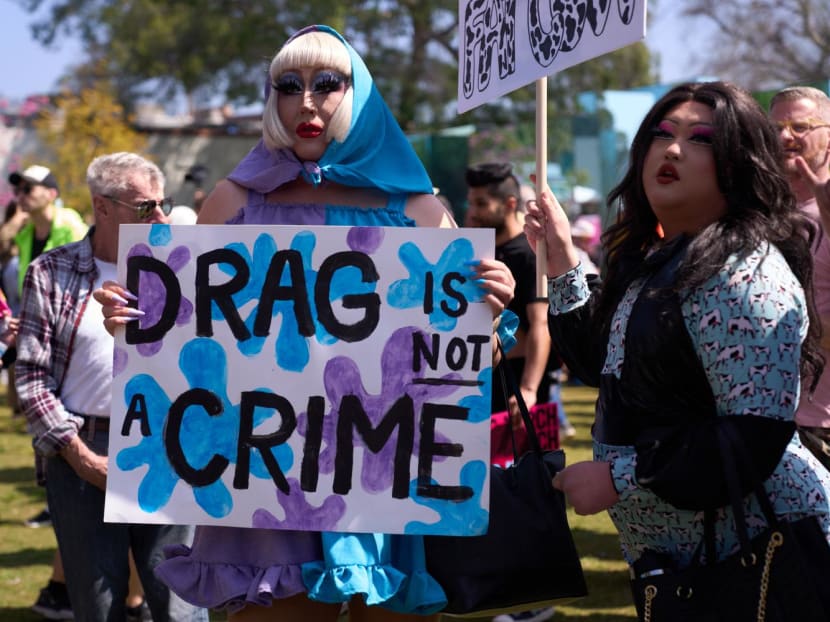 LGBTQ+ activists hold a sign reading "Drag is Not a Crime" as they march during the Los Angeles LGBT Center's Drag March LA: The March on Santa Monica Boulevard in West Hollywood, California, on April 9, 2023.