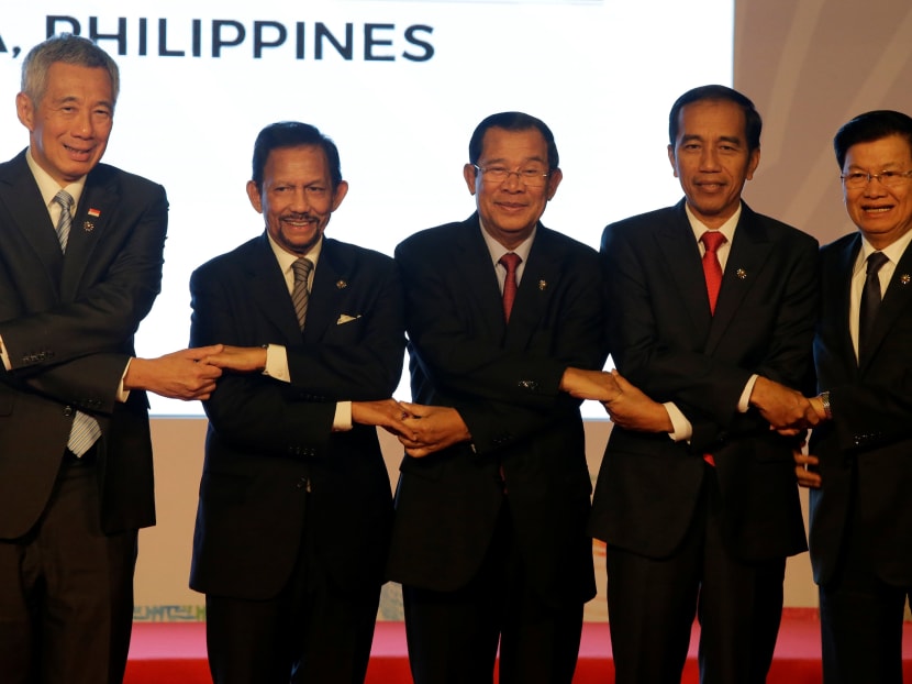 (L-R) Singapore Prime Minister Lee Hsien Loong, Brunei Sultan Hassanal Bolkiah, Cambodia Prime Minister Hun Sen, Indonesia President Joko Widodo and Laos Prime Minister Thongloun Sisoulith, join hands during a family photo before the 31st ASEAN Summit in Manila. Photo: Reuters