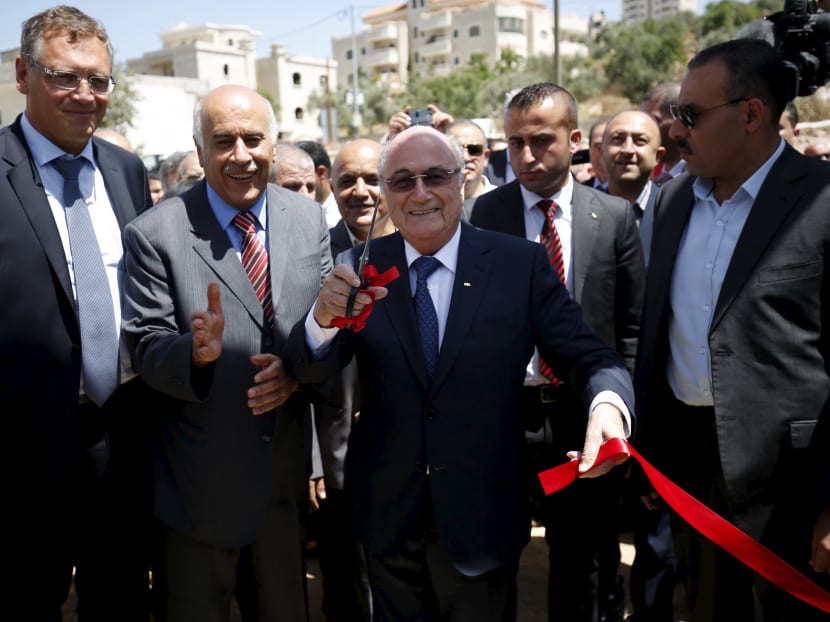 FIFA chief Sepp Blatter (centre) gestures as he cuts the ribbon to open a playground during his visit to Dura al-Qar' village in the West Bank city of Ramallah. Photo: Reuters