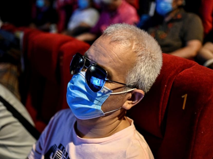 This photo taken on Aug 7, 2021 shows visually impaired massage therapist Zhang Xinsheng listening to the film narrator during a screening at a cinema in Beijing.