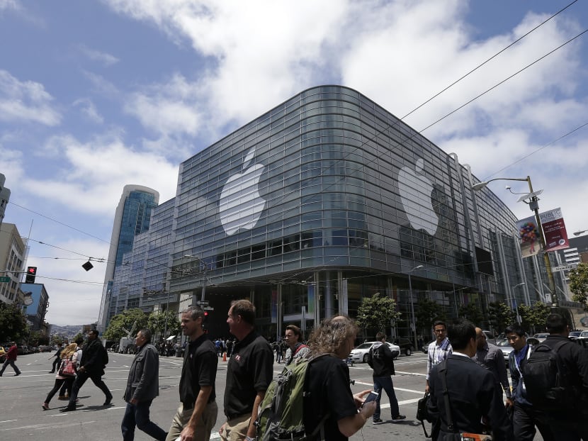In this June 2, 2014 file photo, pedestrians cross the street in front of the Moscone Center, which is hosting the Apple Worldwide Developers Conference, in San Francisco. Photo: AP