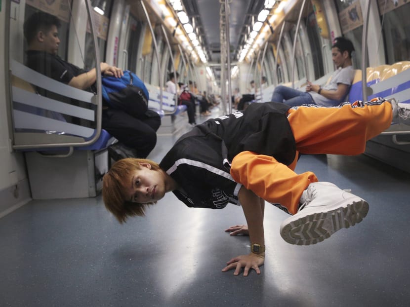 Freddy Yohaki demonstrates a dance move onboard the MRT. Photo: Jason Quah/TODAY