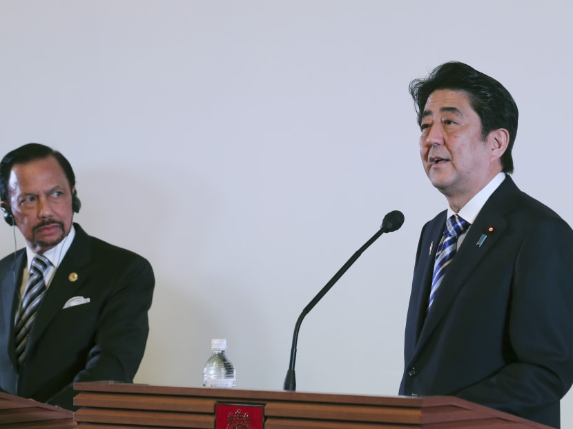 Japanese Prime Minister Shinzo Abe (right) speaks next to Brunei Sultan Hassanal Bolkiah, chairman of the ASIAN-Japan summit, during a joint press announcement at Akasaka State Guesthouse in Tokyo,  Dec 14, 2013. Photo: AP