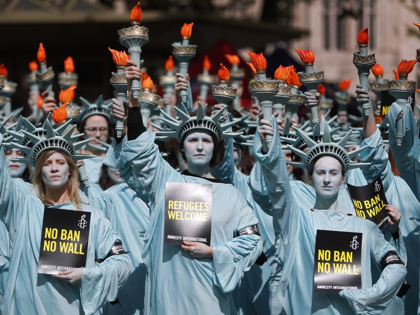 One hundred Amnesty International protesters dressed as the Statue of Liberty demonstrate outside the US Embassy in London, as US President Donald Trump's prepares to mark first 100 days in office. Photo: AP