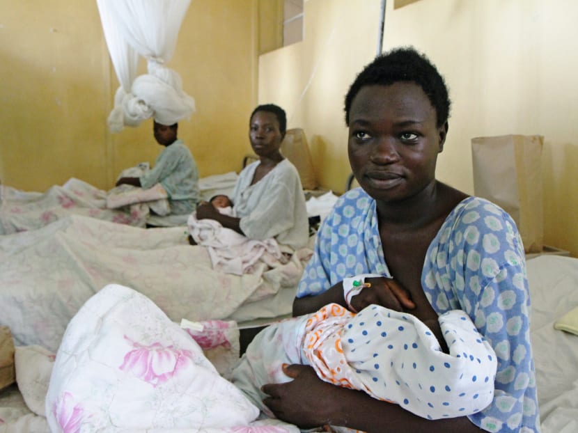 Mothers and participants in Rwanda's "RapidSMS" health system pose with their newborns on April 27, 2016 in Nyarukombe. The “RapidSMS” database of the Rwandan Ministry of Health will hold basic information about pregnant woman and patients like her, though information such as ID number and if it is her first pregnancy or not is recorded. Photo: AFP