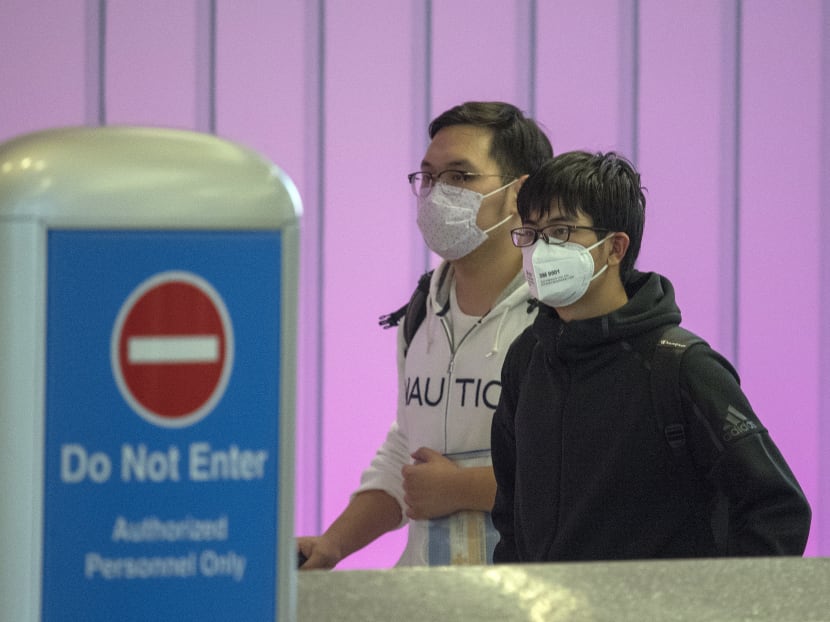 Passengers wear face masks to protect against the spread of the Coronavirus as they arrive on a flight from Asia at Los Angeles International Airport, California, on Jan 29, 2020.