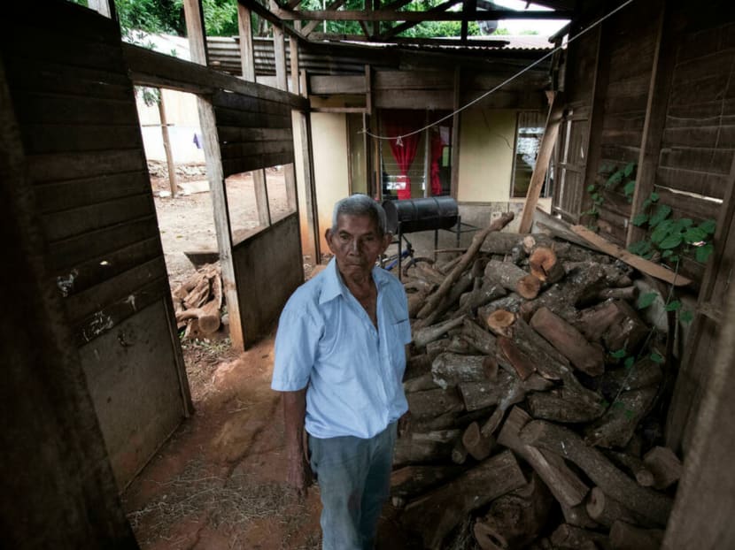 Saturnino Lopez, 94, stands next to a pile of firewood at his home in Nicoya, Costa Rica, on August 27, 2021