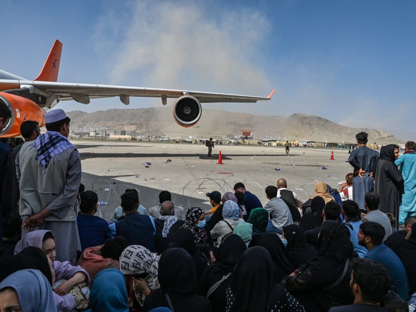 Afghan people wait to leave the airport in Kabul on Aug 16, 2021, after the end to Afghanistan's 20-year war.