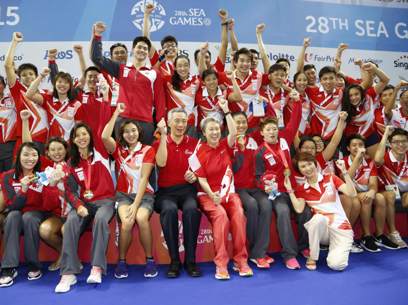Prime Minister Lee Hsien Loong (C) and his wife Ho Ching pose for a photo with Singapore athletes and staff after the medal ceremony. Photo: Reuters