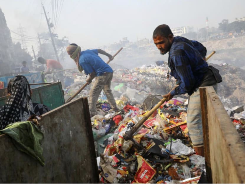 Workers dump waste in the bank of Buriganga River in Dhaka, Bangladesh, on Jan 2, 2020.
