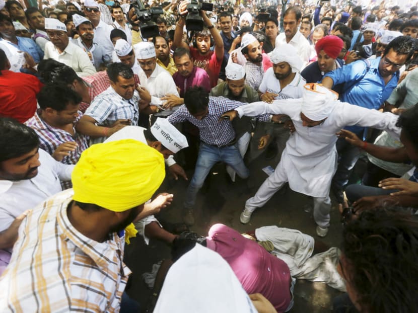 Protesters gather around a farmer who hanged himself from a tree during an AAP rally in New Delhi on Wednesday. The body was released to the crowd below after he died. Photo: Reuters