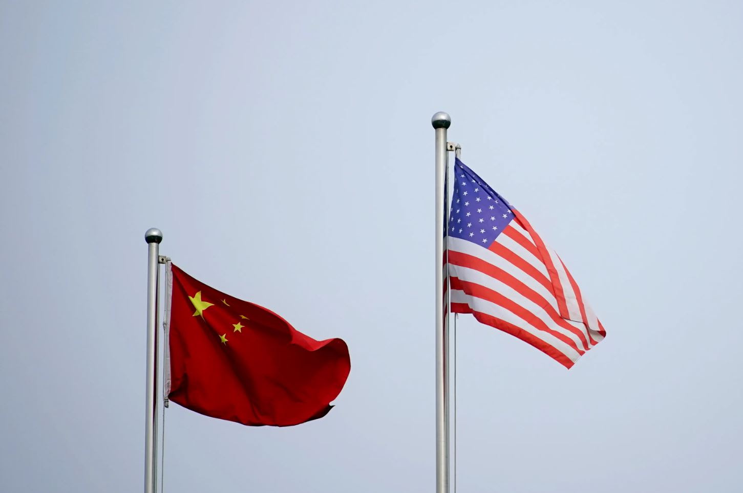 Chinese and US flags flutter outside a company building in Shanghai, China on April 14, 2021. 

