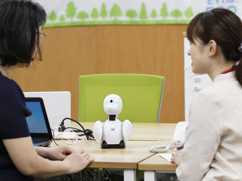 A worker uses the OriHime communication robot to talk to a male colleague who is working from home. Photo: Kyodo