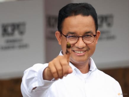 Presidential candidate Anies Baswedan shows his ink-stained finger after casting his vote at a polling station during the general election in Jakarta, Indonesia, on Feb 14, 2024.