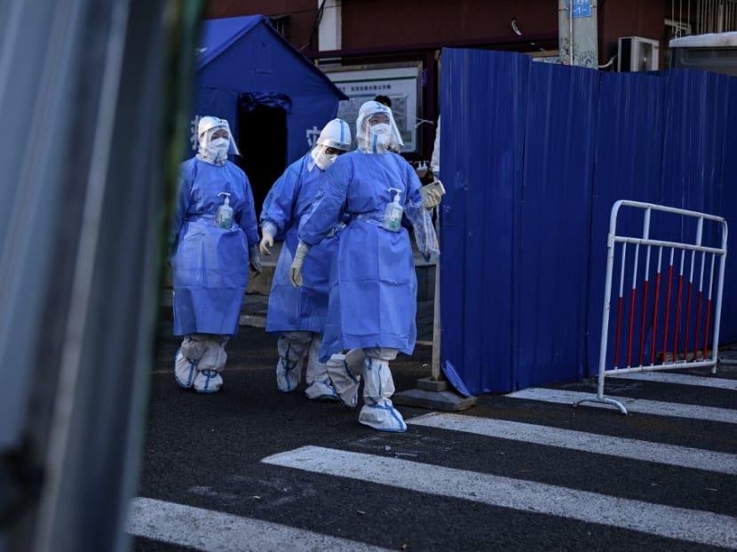 Health workers are seen at a residential area under lockdown due to Covid-19 restrictions in Beijing on Nov 13, 2022. Health workers are seen at a residential area under lockdown due to Covid-19 restrictions in Beijing on Nov 13, 2022.
