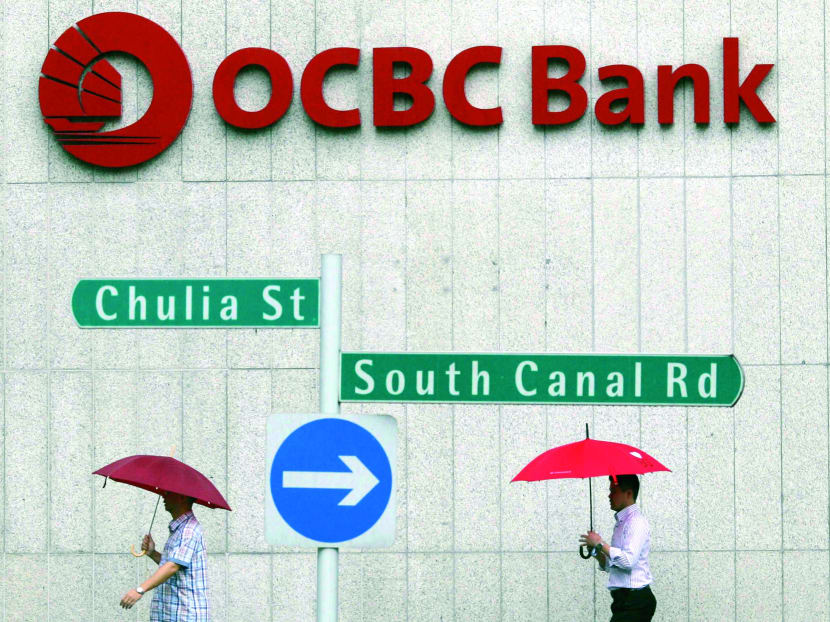 Office workers pass an Oversea-Chinese Banking Corp (OCBC) building in the central business district of Singapore. Photo: Reuters