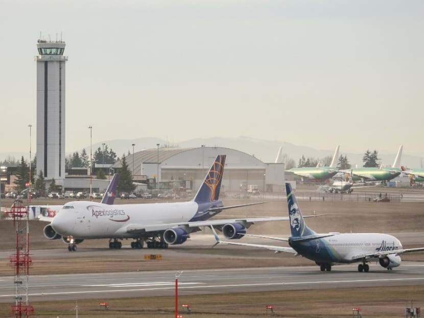 An Alaska Airlines Boeing 737-800 airplane, right, takes off as the final 747 airplane produced by Boeing, a 747-8 Freighter for Atlas Air, taxis before take off from Paine Field in Everett, Washington on Feb 1, 2023. 